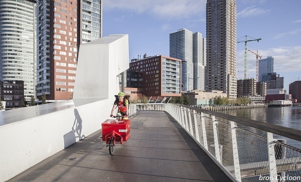 Duurzaam bezorgen van relatiegeschenken - fietskoerier_in_stad_met_bron